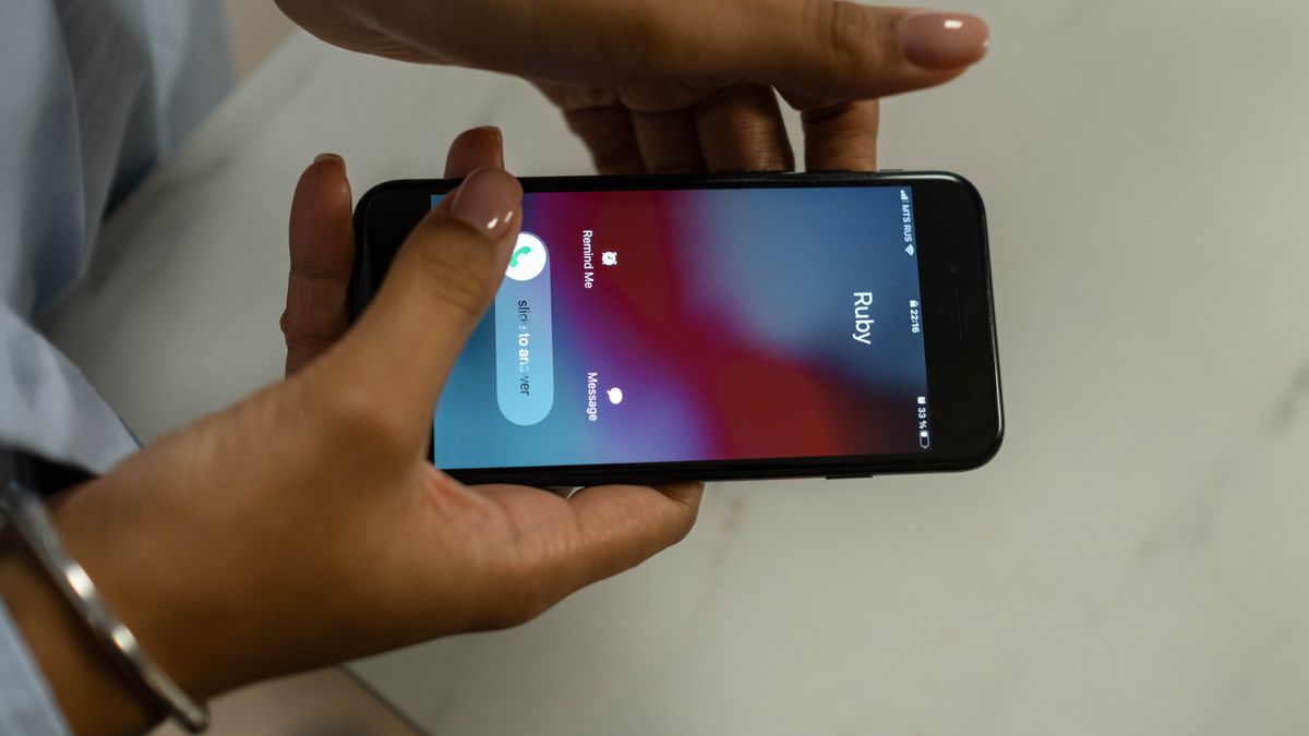 スマートフォンに着信があり手に取っているイメージ