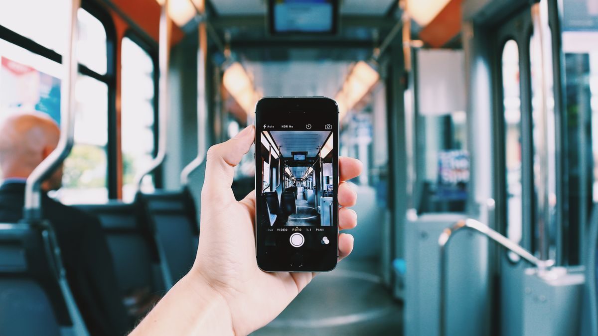 電車の中でスマートフォンを操作している手元
