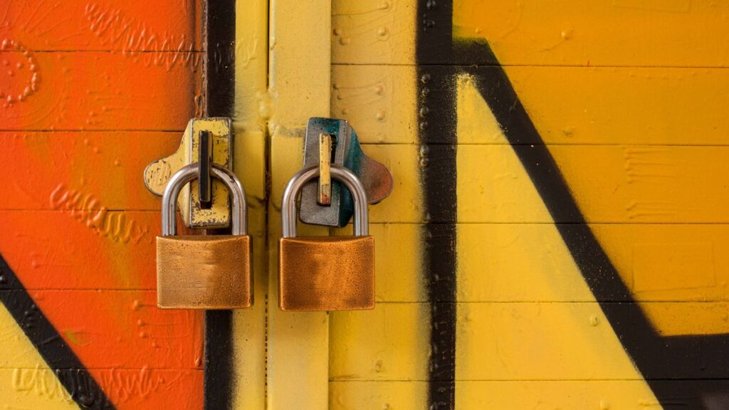 扉に並んで掛かった2つの南京錠。BufferでFacebookページの権限を2箇所で確認する必要があることのイメージ
