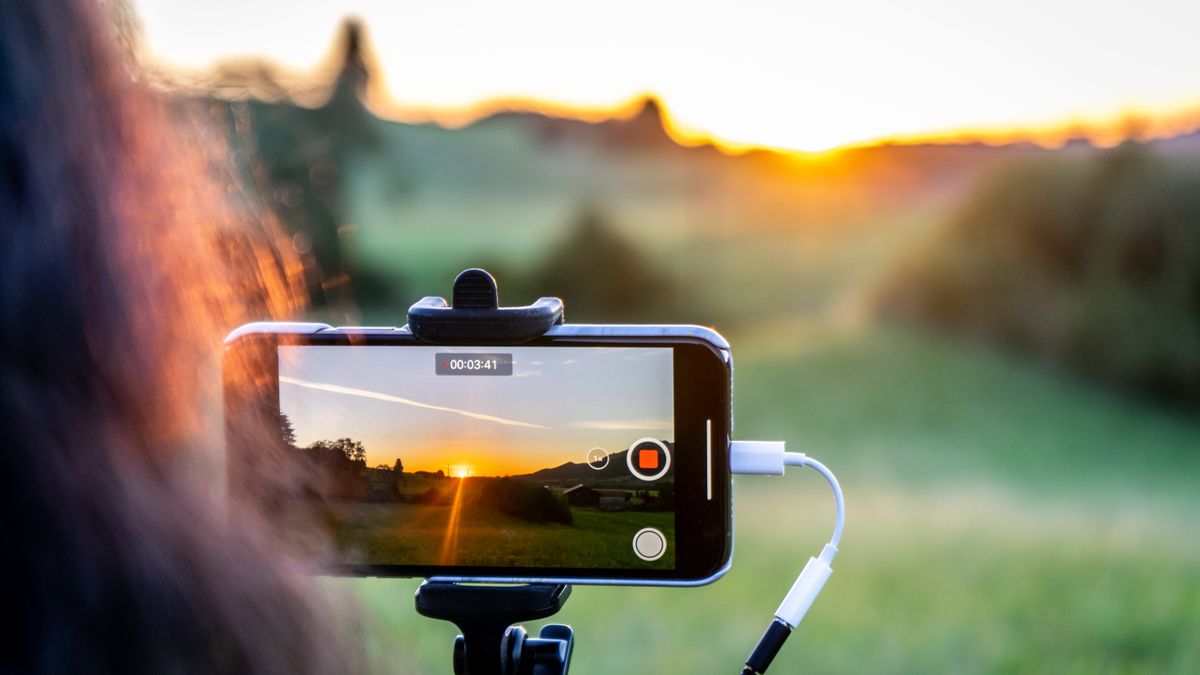三脚に載せたスマートフォンで夕景を録画している様子。BufferでInstagramのリール・ストーリーズを予約する方法のイメージ