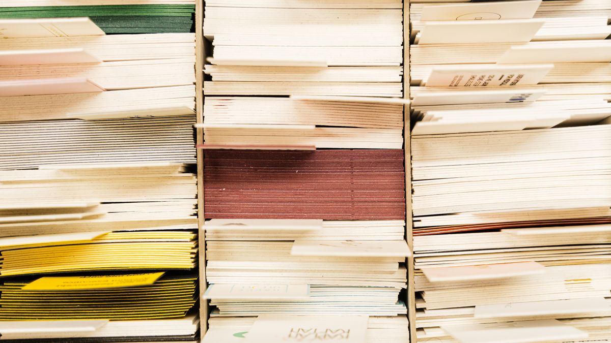 重なり合った大量の書類の断面。顧客リストの重複を表すイメージ