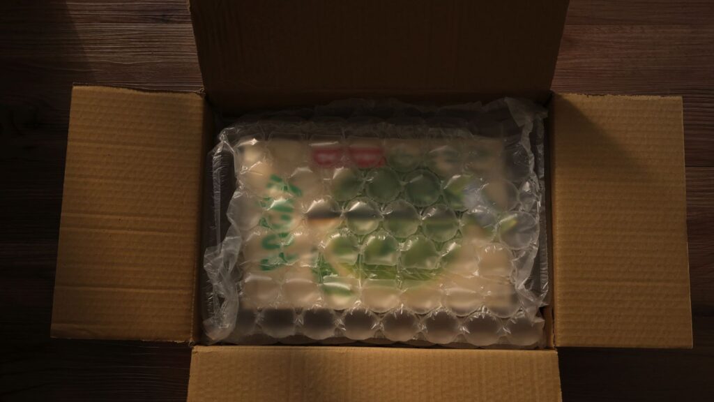 開けたダンボール箱の中で商品が緩衝材に包まれて収まっている様子