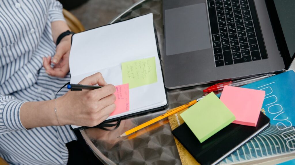 ノートに見出しを書き出して記事の構成を組み立てている手元