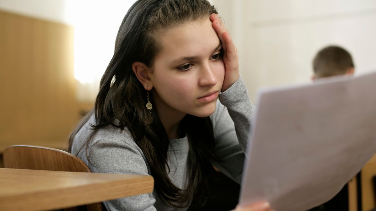 書類に目を通しながら考えている若い女性