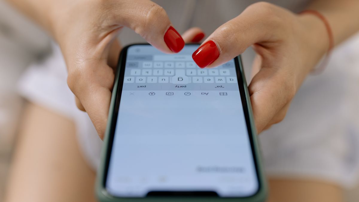 スマートフォンでメッセージを打っている手元