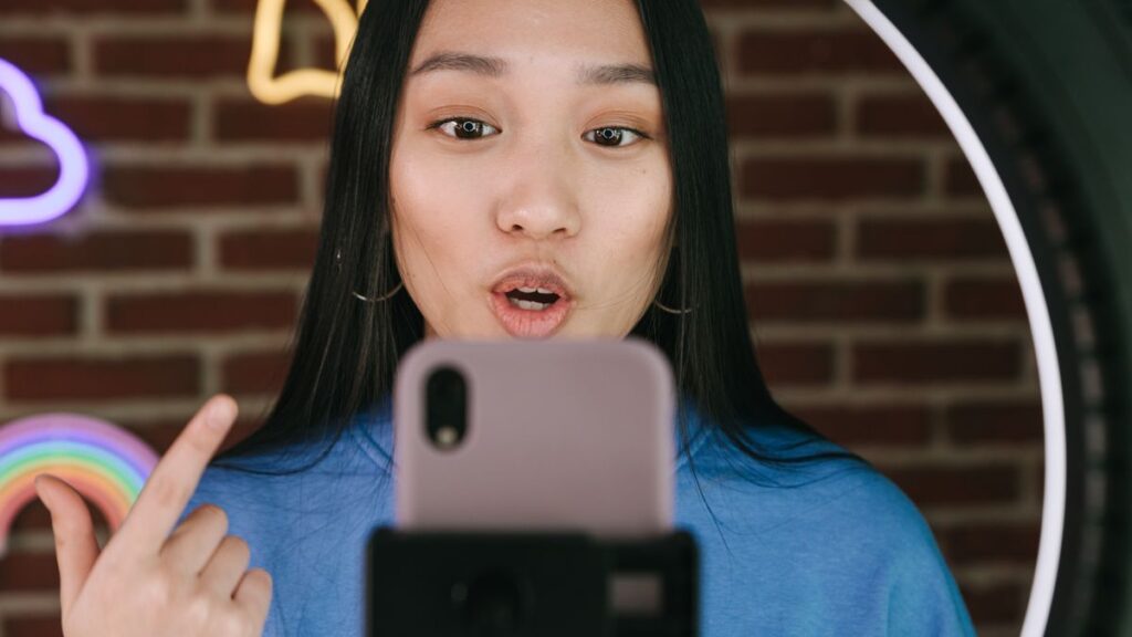 リングライトの前でスマートフォンに向かって話しかける女性ライバー