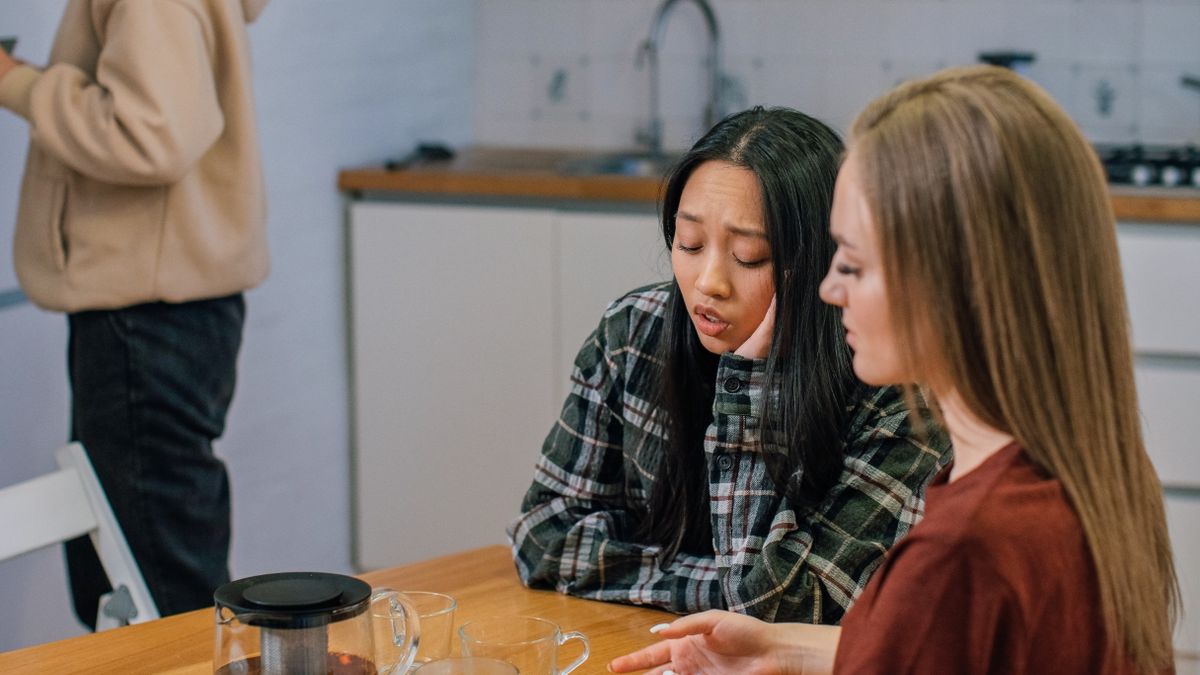 テーブルでお茶を前に向かい合って話している2人の女性