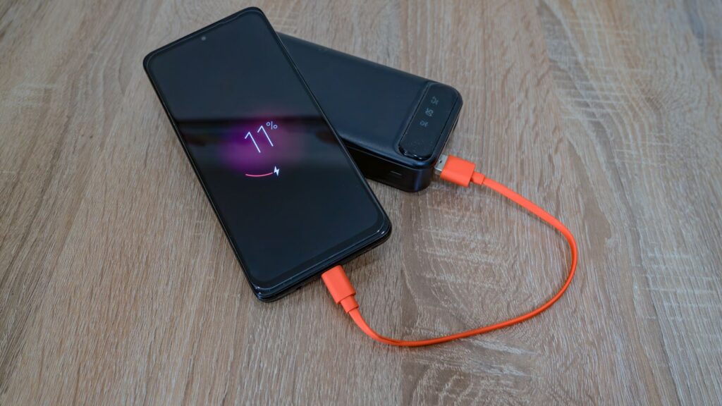 スマートフォンがモバイルバッテリーにケーブルで接続され充電されている様子