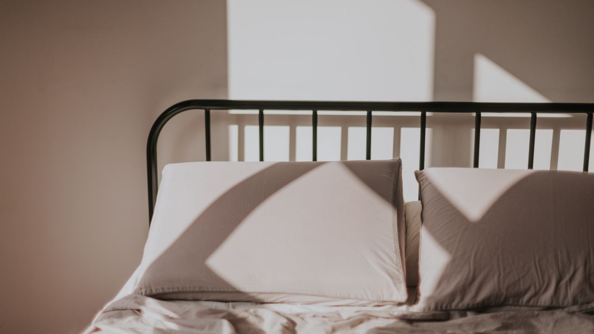 朝の光が差し込むベッドと枕。睡眠を整えるイメージ