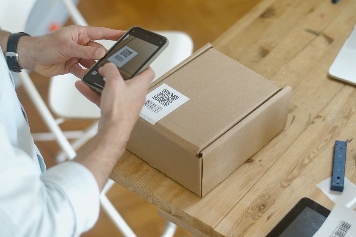 スマートフォンで荷物のQRコードを読み取っているところ